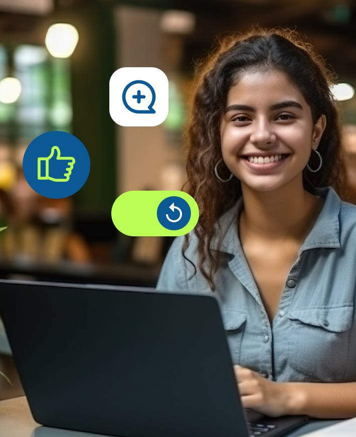 Mulher jovem de cabelos compridos e ondulados, sorrindo em frente ao seu laptop em seu local de trabalho.